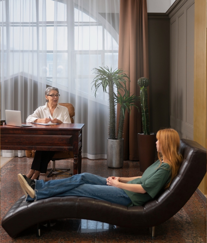 Consultation d’hypnose avec une cliente allongée sur une méridienne face à une praticienne