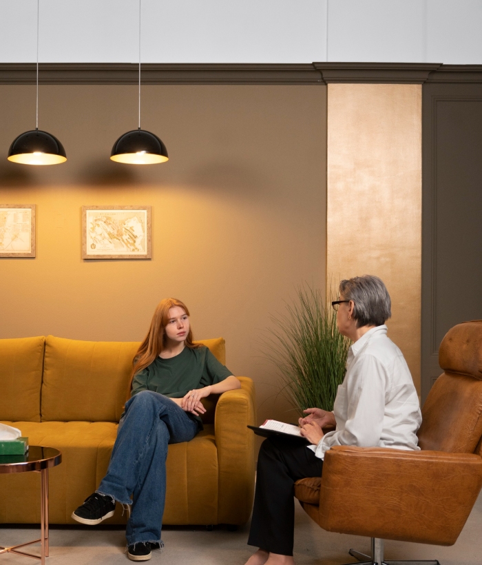 Séance d’hypnose en cabinet avec une praticienne échangeant avec une jeune cliente